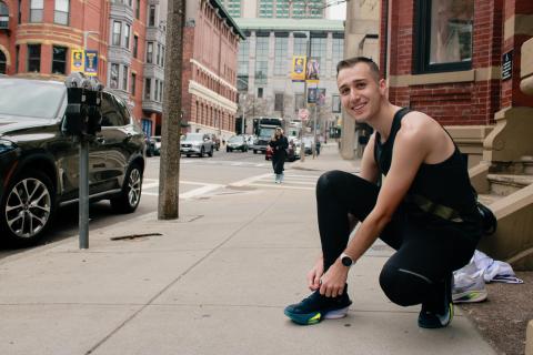 Xander Dawson tying his shoe on a street in Back Bay