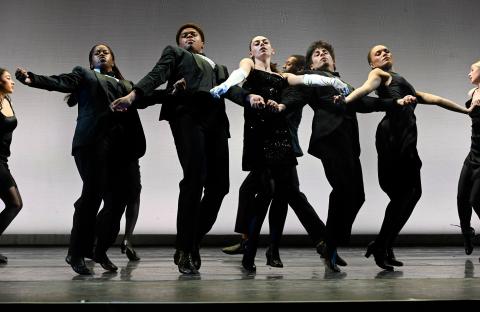 Dance students performing on stage in black outfits