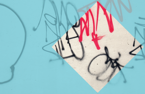 A wall with red and black graffiti. There is a blue hue overlay with a clear diamond cutout.